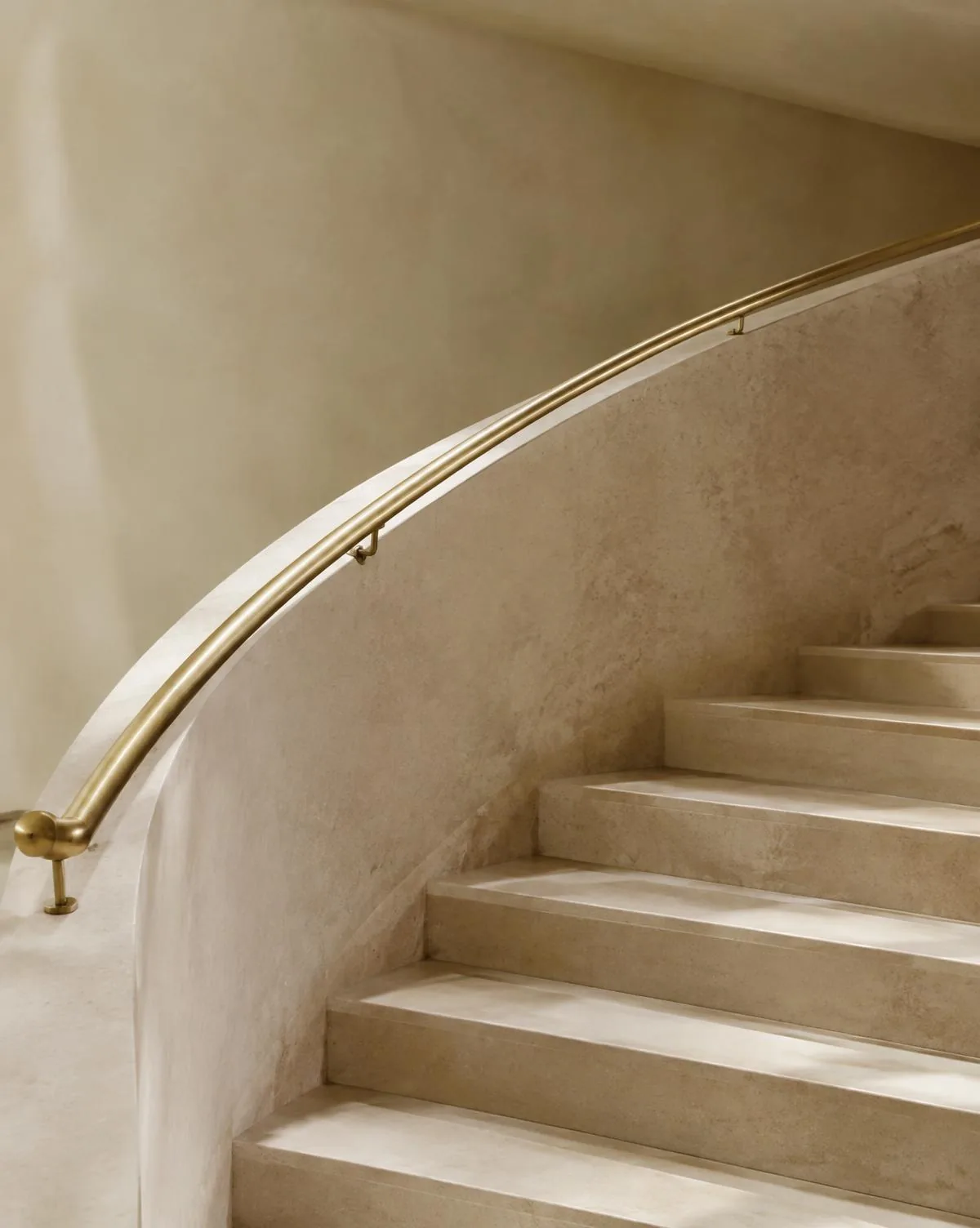 Escalier de pierre courbe et main courante en laiton